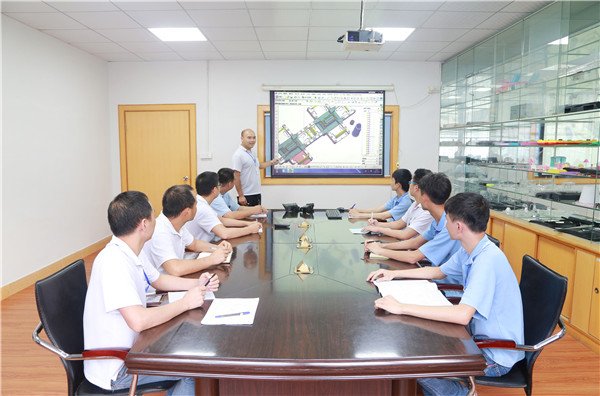 Engineering team analyzing DFM report together at a workstation