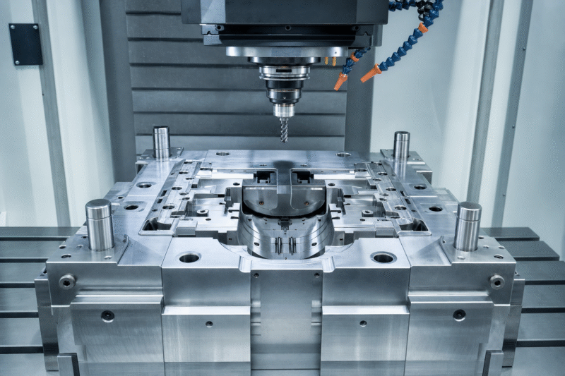 A CNC machine cutting a block of steel for a mold